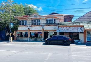 a car parked in front of a building on a street at RedDoorz @ Plaza La Paz Iloilo City in Iloilo City