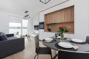 une salle à manger et un salon avec une table et des chaises dans l'établissement Posesja Kapitańska Przy Plaży Apartments Grzybowo by Noclegi Renters, à Grzybowo