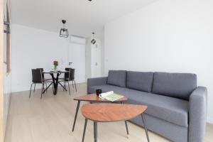 un salon avec un canapé et une table dans l'établissement Posesja Kapitańska Przy Plaży Apartments Grzybowo by Noclegi Renters, à Grzybowo
