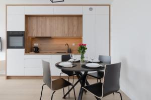 une salle à manger avec une table et des chaises noires dans l'établissement Posesja Kapitańska Przy Plaży Apartments Grzybowo by Noclegi Renters, à Grzybowo