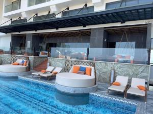 a swimming pool with lounge chairs next to a building at Apec mandala new Phú yên in Tuy Hoa