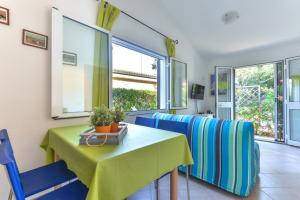 a dining room with a green table and blue chairs at Unifamiliare Isola D'elba in Porto Azzurro