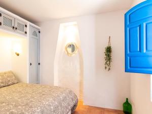 a bedroom with a bed and a blue door at Casa Las Niñas in Pinos del Valle