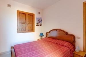 a bedroom with a bed with a red striped blanket at Torre dei corsari - Dune d'oro in Torre Dei Corsari