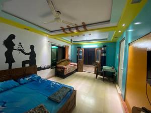 アリバグにあるWoods Prashanti Homestayのベッドと壁に絵が飾られた寝室