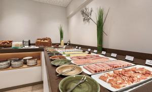 ein Buffet mit vielen verschiedenen Speisen auf dem Tisch in der Unterkunft Wyndham Garden Munich Messe in München