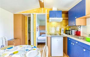 - une cuisine avec des armoires bleues et une table dans une pièce dans l'établissement 2 Bedroom Nice Apartment In Gages, à Agen dʼAveyron