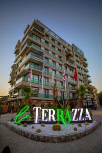 un grand bâtiment avec un panneau devant lui dans l'établissement La Terrazza Hotel, à Famagouste