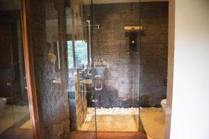 een douche met een glazen deur in de badkamer bij The Kayon Jungle Resort in Ubud