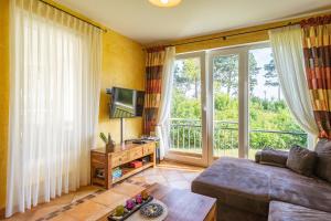 a living room with a couch and a large window at Ferienwohnung Romantica am Strand von Juliusruh in Juliusruh