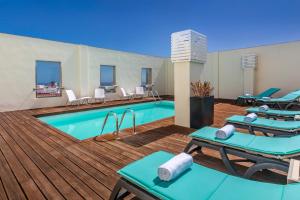 una piscina con sillas y una terraza con piscina en Occidental Santa Cruz Contemporáneo en Santa Cruz de Tenerife