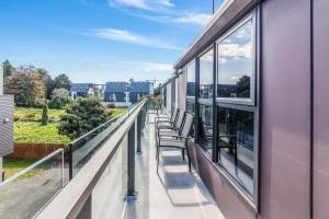 a row of chairs on the balcony of a building at Alexander Inn in Auckland