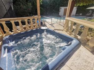 eine Whirlpool-Badewanne im Hinterhof in der Unterkunft Villa avec piscine et jacuzzi en bordure de forêt in Roquefort-les-Pins