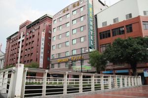 une clôture blanche devant un bâtiment dans l'établissement Riverside Hotel, à Kaohsiung