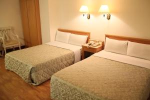 En eller flere senge i et værelse på Riverside Hotel