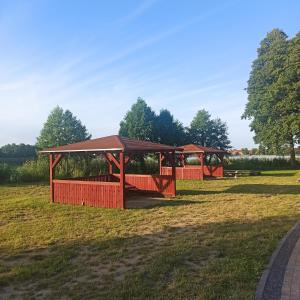 einen Pavillon auf einem Feld mit Bäumen im Hintergrund in der Unterkunft Pojezierze wałeckie kusi atrakcjami in Wałcz