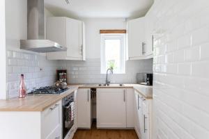- une cuisine blanche avec des placards blancs et un évier dans l'établissement Afan Forest House - Private doubles or Twin options! Perfect for Contractors!, à Port Talbot