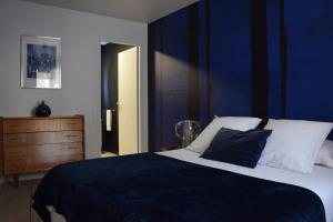 - une chambre avec un grand lit et un mur bleu dans l'établissement La Bâtie - Terrasse avec Vue imprenable sur le Rhône, 3 chambres, 3 salles de bain, à Tain-lʼHermitage