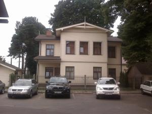 three cars parked in a parking lot in front of a house at Jomas 24 in Jūrmala