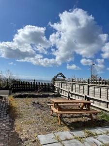 a wooden picnic table in front of a fence at Swansea Townhouse Perfect for contractors Private double rooms in Swansea