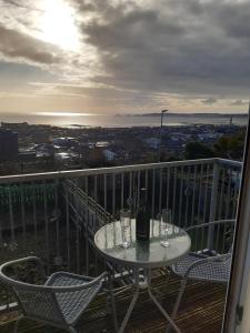 a table with a bottle of wine and glasses on a balcony at Swansea Townhouse Perfect for contractors Private double rooms in Swansea