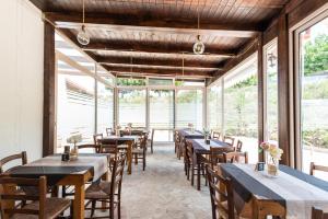 a dining room with tables and chairs and windows at B&B Agriturismo Tenuta Barone in Gallipoli