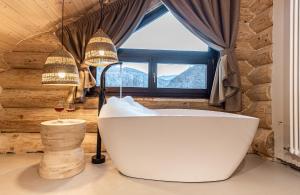 a bath tub in a room with a window at Casa din Vale in Săcuieu