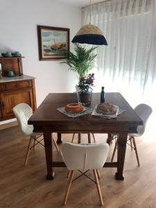 Ría de Navia في نافيا: طاولة غرفة طعام مع كراسي بيضاء وطاولة