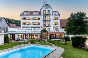 duży biały budynek z basenem przed nim w obiekcie Genussgasthof & Hotel beim Krutzler w mieście Heiligenbrunn