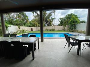 un patio con mesa, sillas y piscina en Villa Ad Homestay, en Ampang