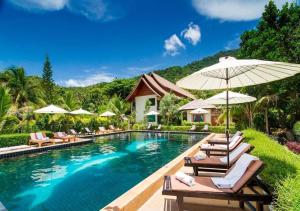 a swimming pool with lounge chairs and umbrellas at Starlight Resort Koh Phangan in Thong Nai Pan Yai