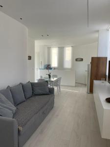 a living room with a gray couch and a table at BREZZA DI MARE - attico vista mare con terrazza in Termoli