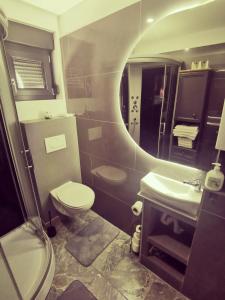 a bathroom with a toilet and a sink and a mirror at Apartmani KA Sveti Martin in Sveti Martin na Muri +24 photos