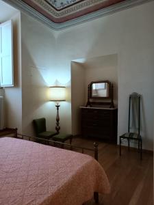 sypialnia z łóżkiem, lustrem i krzesłem w obiekcie Palazzo Bianchi Bandinelli by FrancigenaApartments w Sienie +21 zdjęć