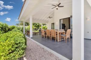 a dining room with a table and chairs on a patio at Grand Windsock Bonaire in Kralendijk