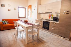 een keuken met een tafel en stoelen en een bank bij Albergo Diffuso Dolomiti in Forni di Sotto
