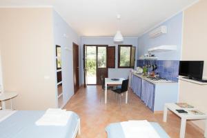 cocina y sala de estar con cama y mesa en Le Terrazze Su Fraginesi, en Castellammare del Golfo
