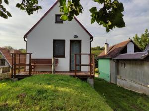 a small white house with a wooden deck at Vojtěch Jestřáb - rodinné vinařství in Mutěnice