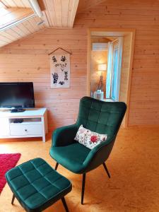 a green chair and a stool in a room at HERBALIJA Apartment Herbalija - sorrounded by Nature in Podčetrtek