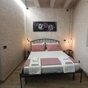 una camera da letto con un grande letto con cuscini rosa di Chiaro di Luna - Casa Vacanze a Roma