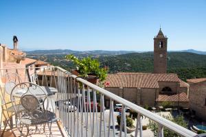 a balcony with a table and chairs and a church at Bed & Breakfast Zia Menga - Luogosanto Sardinia in Luogosanto