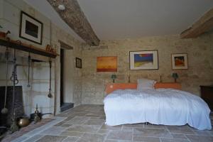 um quarto com uma cama numa parede de pedra em Ferme du bois de Veude em Anché