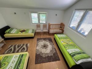 ein Wohnzimmer mit 2 Betten und einem Kinderbett in der Unterkunft Kuca Delić in Račić