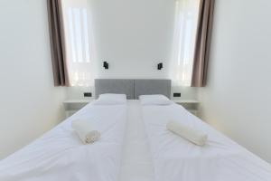 1 cama blanca grande con 2 almohadas blancas. en Villa Oliver Zalakaros, en Zalakaros