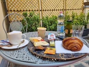 una mesa con un plato de comida y una taza de café en B&B The Lux en Florence