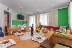 jadalnia i salon z drewnianym stołem w obiekcie Haus Garten An der Sonne w mieście Niedernsill