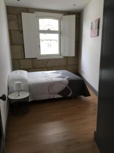 una camera da letto con un letto e una finestra di Apartamento, Praça Dom Duarte 8, Viseu, Portugal a Viseu