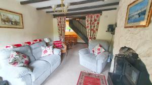 a living room with two couches and a fireplace at River Cottage in St Asaph