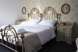 una camera da letto con un grande letto bianco con telaio dorato di Villa Nerone B&B a Lorenzana