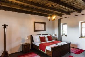 a bedroom with a bed with red pillows at Zsindelyes Cottage in Érpatak